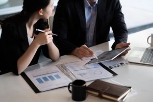 A men and woman at the office discussing reports